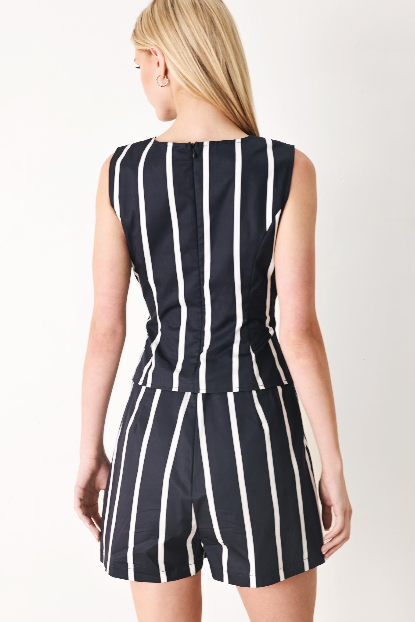 Woman wearing a navy and white striped top and skort set with buttons | FREEMARKET
