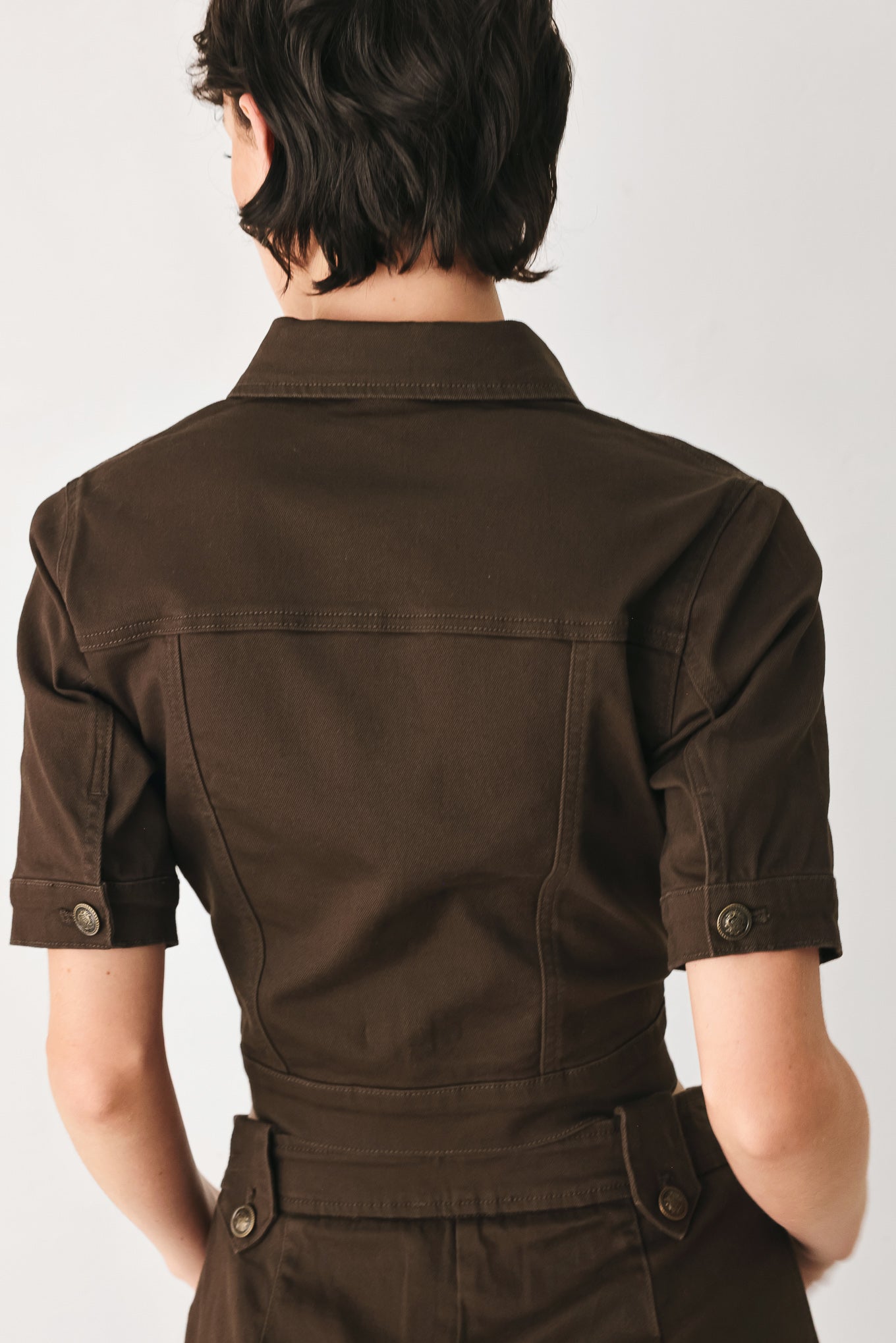 Woman wearing a short sleeve brown denim jacket with collar, V neckline, and front button closure | FREEMARKET
