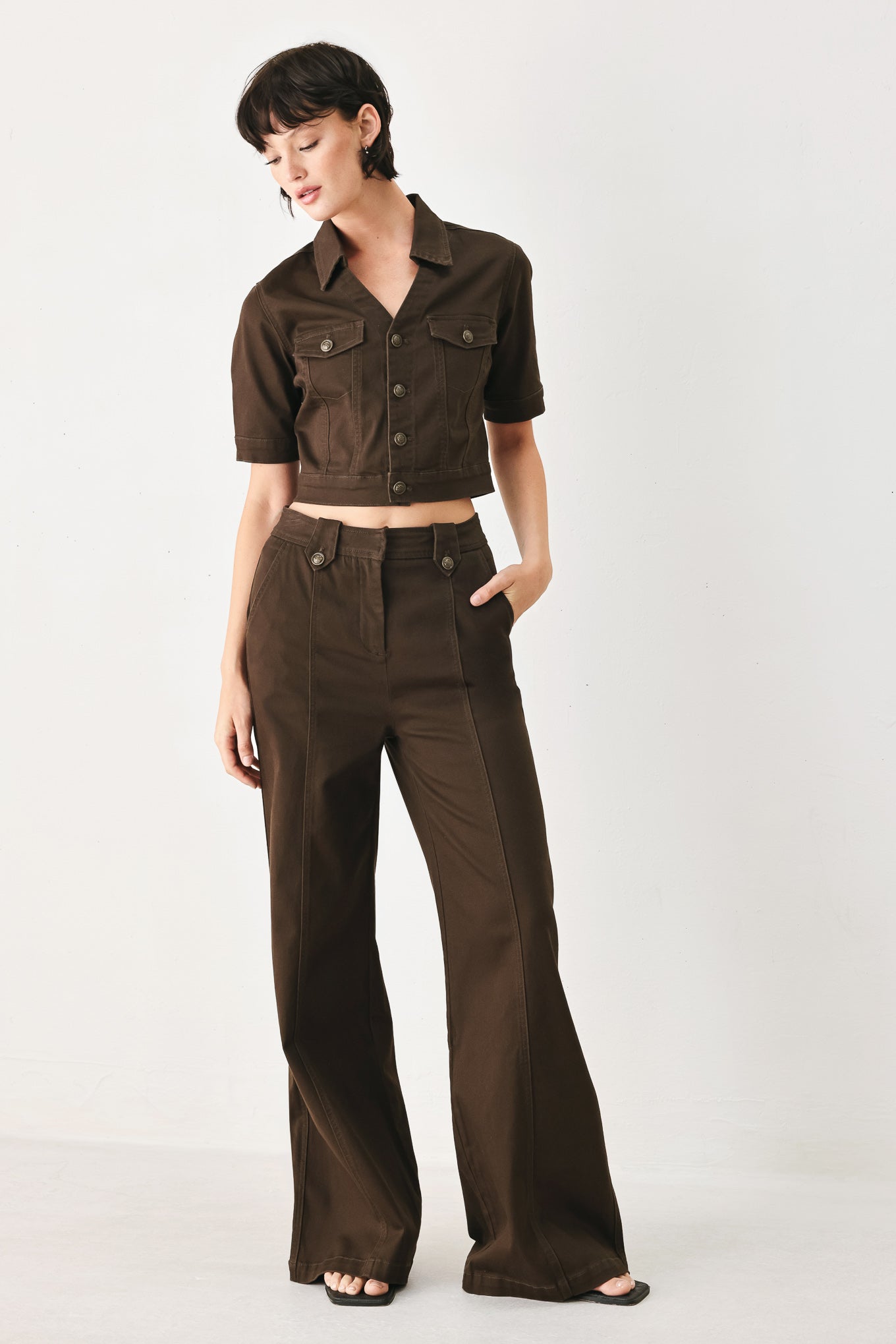 Woman wearing a short sleeve brown denim jacket with collar, V neckline, and front button closure | FREEMARKET