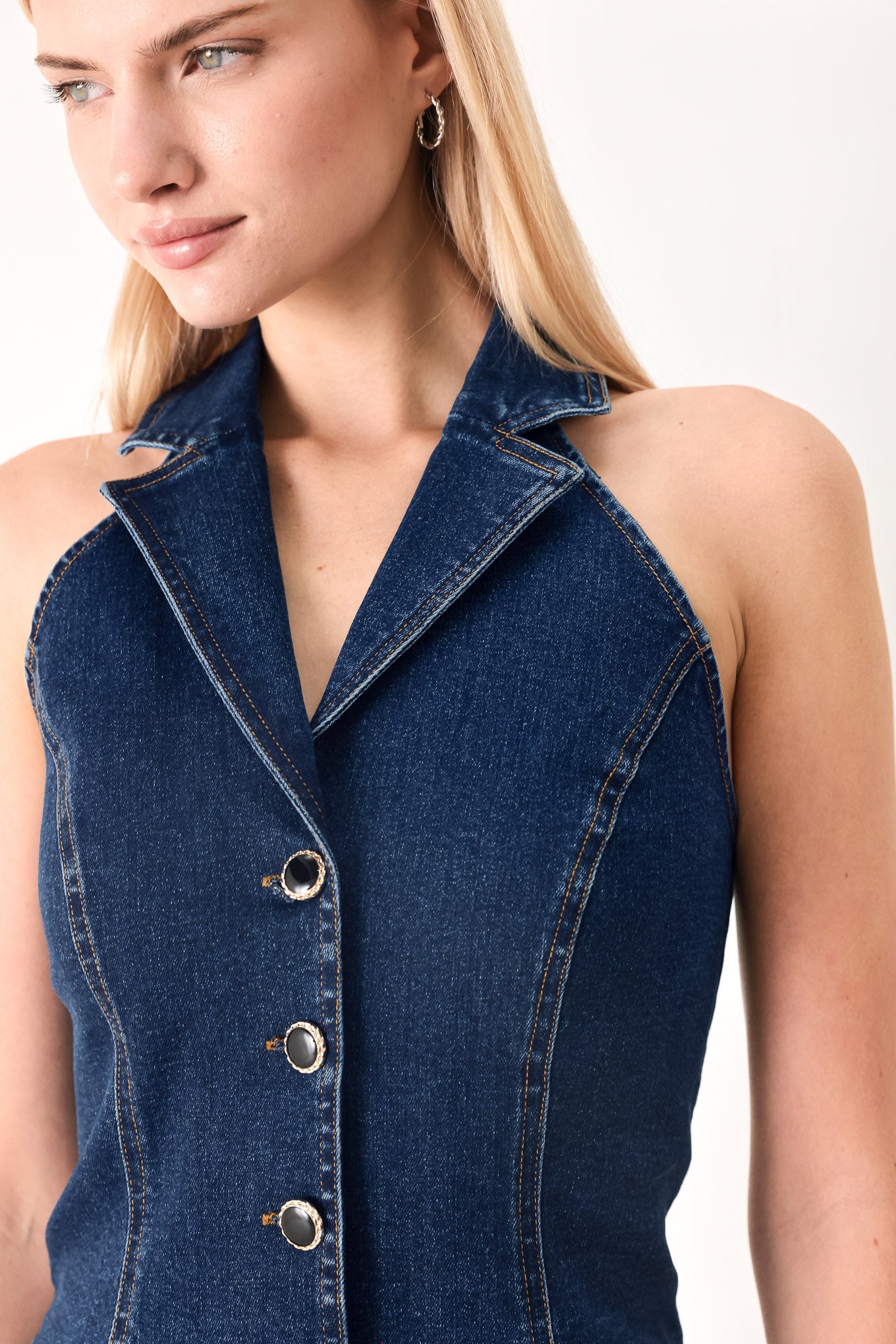 Woman wearing a denim vest with collar and front button closure | FREEMARKET