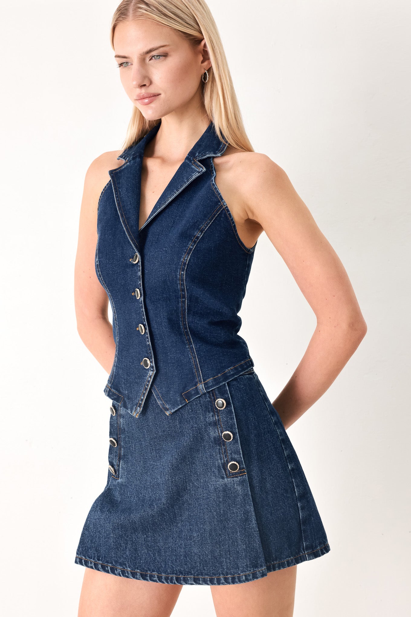 Woman wearing a denim vest with collar and front button closure | FREEMARKET