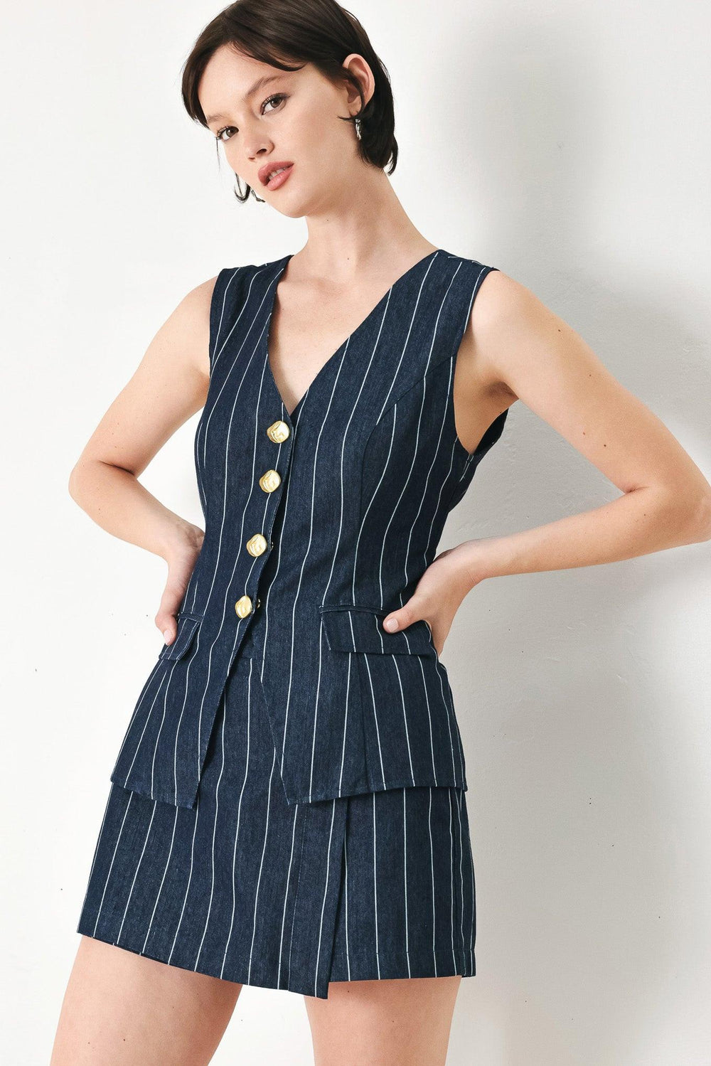 A striped woven vest with V neckline and front button down.