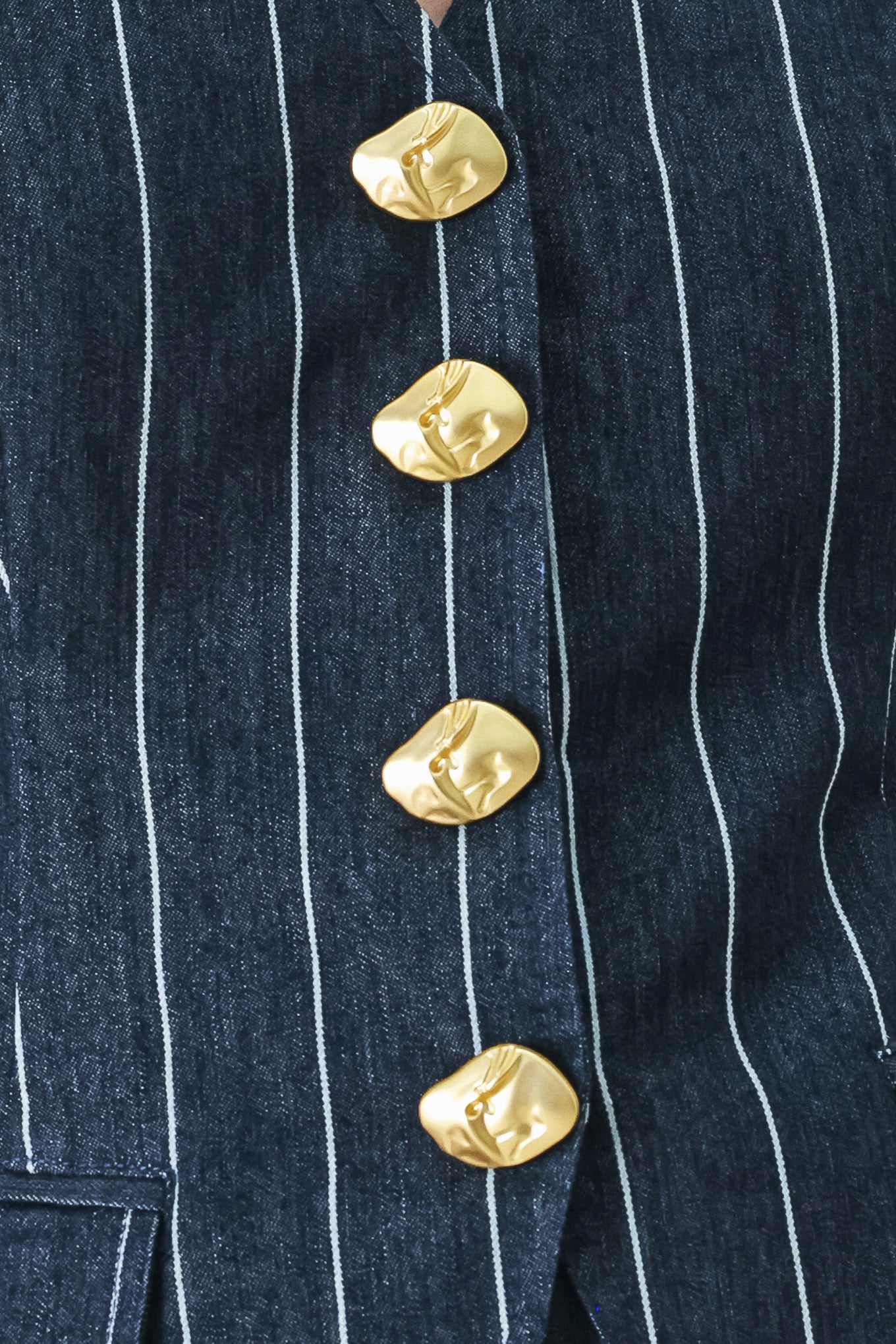 A striped woven vest with V neckline and front button down.