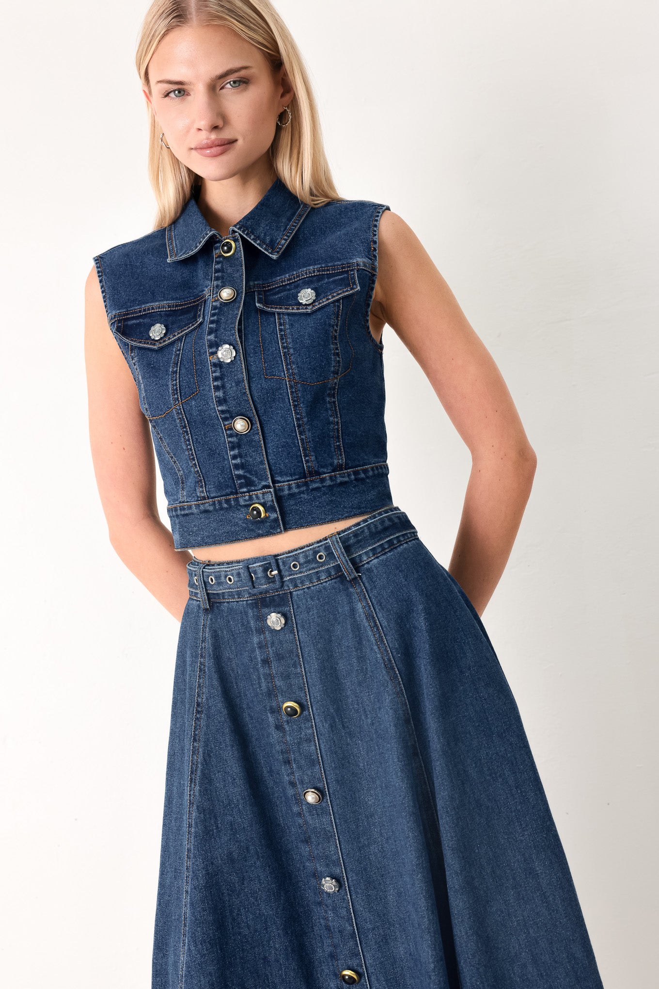 Woman wearing a blue denim cropped vest with front button down and sleeveless | FREEMARKET