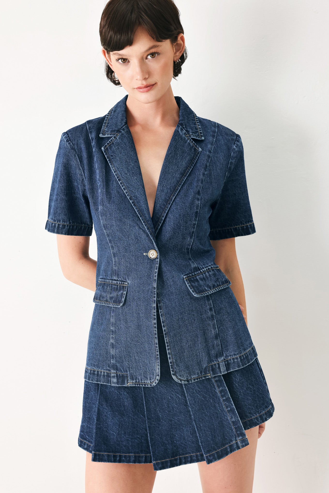 Woman wearing a short sleeve washed denim jacket featuring collar, deep v-cut with a single front button closure | FREEMARKET