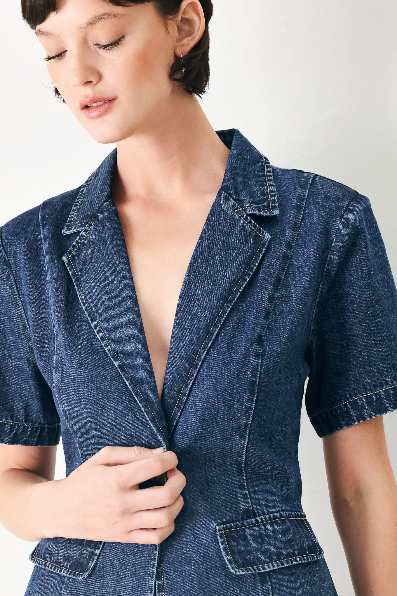 Woman wearing a short sleeve washed denim jacket featuring collar, deep v-cut with a single front button closure | FREEMARKET