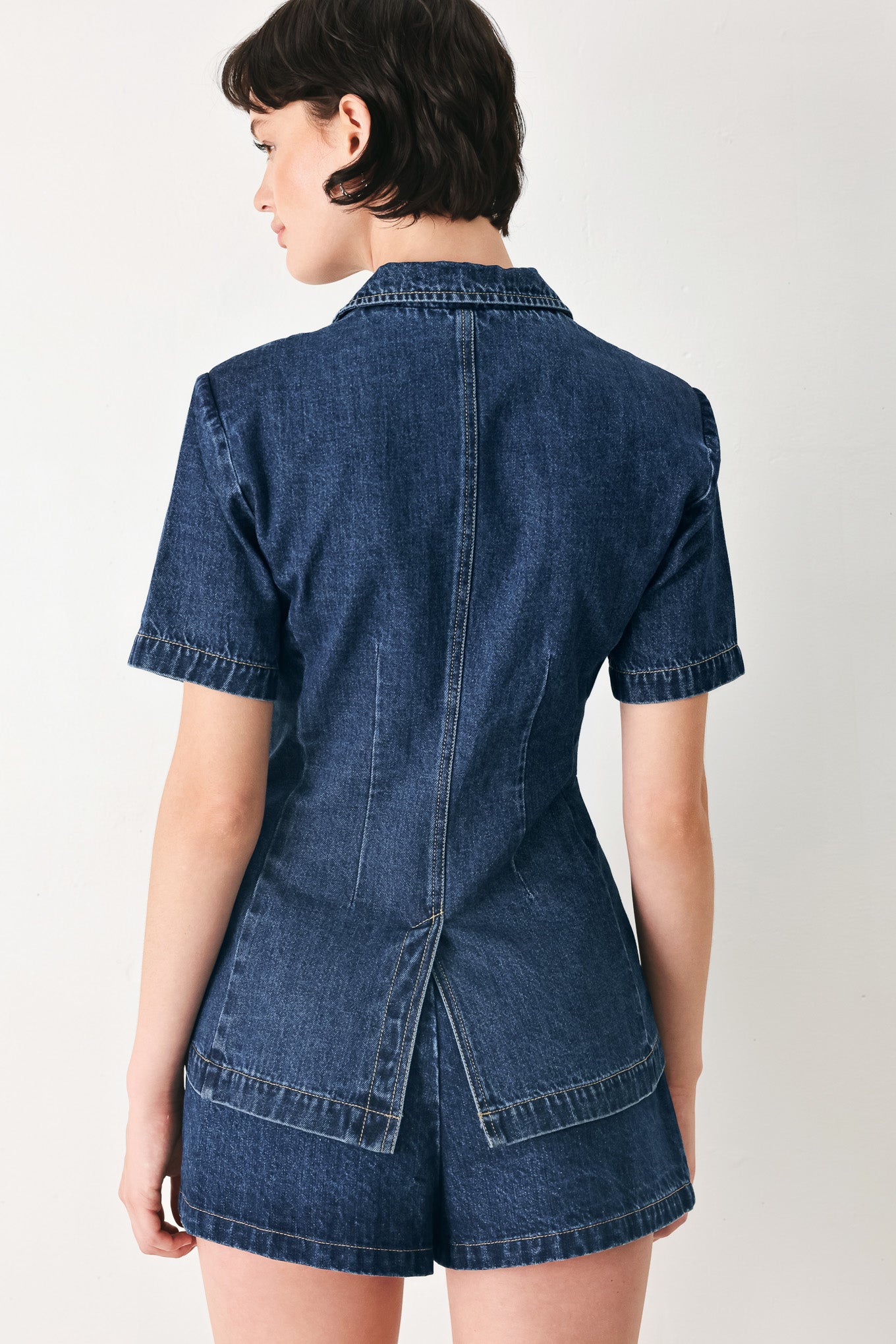 Woman wearing a short sleeve washed denim jacket featuring collar, deep v-cut with a single front button closure | FREEMARKET