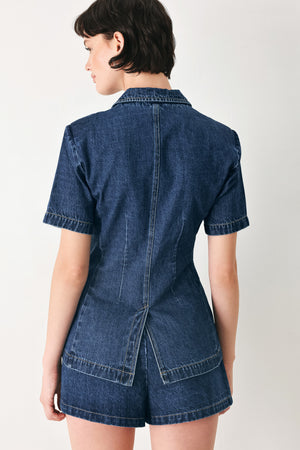 Woman wearing a short sleeve washed denim jacket featuring collar, deep v-cut with a single front button closure | FREEMARKET