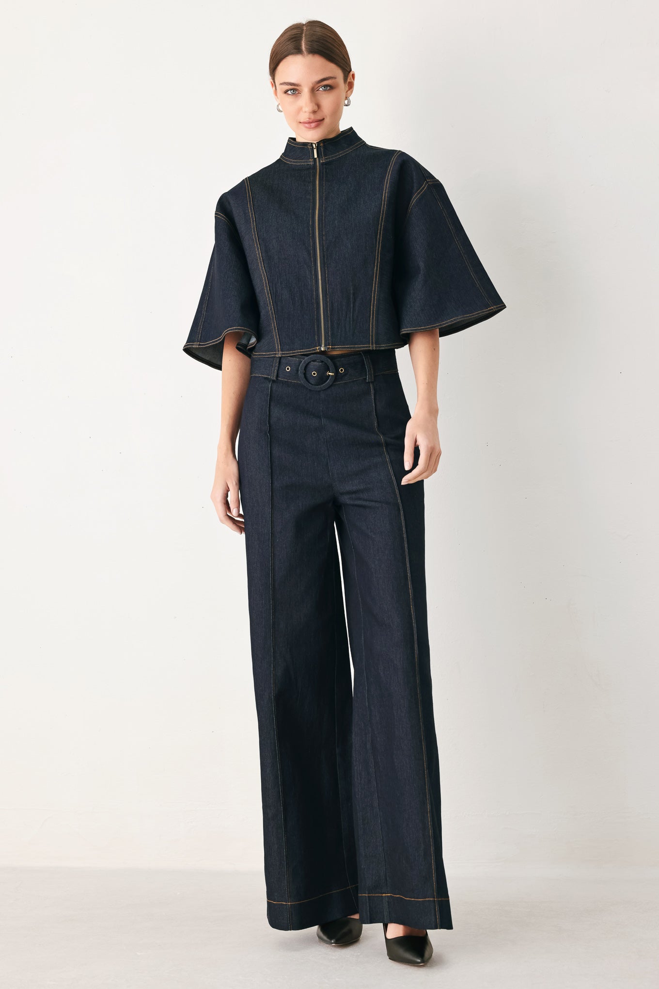 Woman wearing a dark denim capelet top with front zipper closure | FREEMARKET