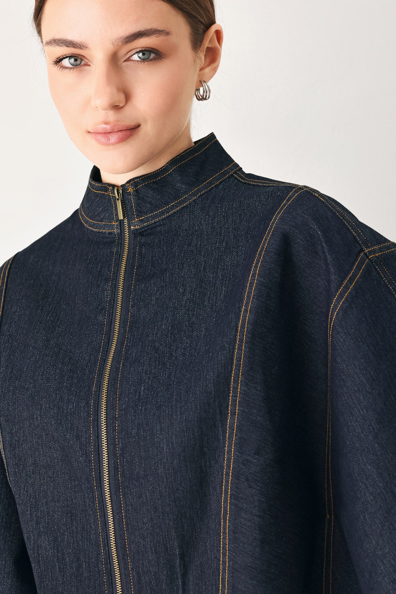 Woman wearing a dark denim capelet top with front zipper closure | FREEMARKET