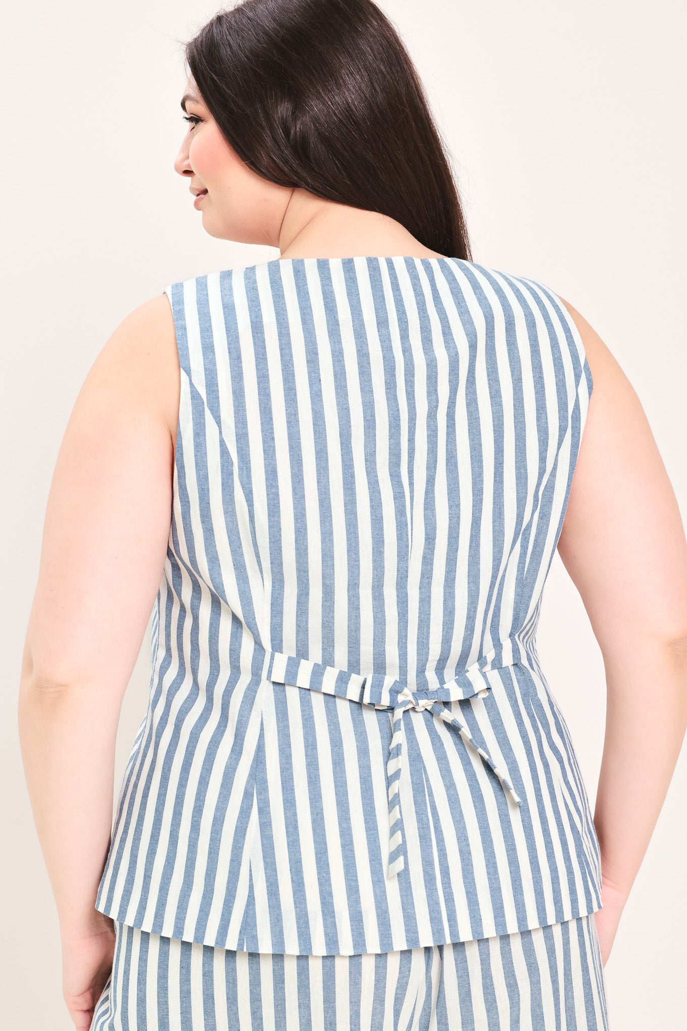 Woman wearing a a striped woven vest with front closure and sleeveless | FREEMARKET