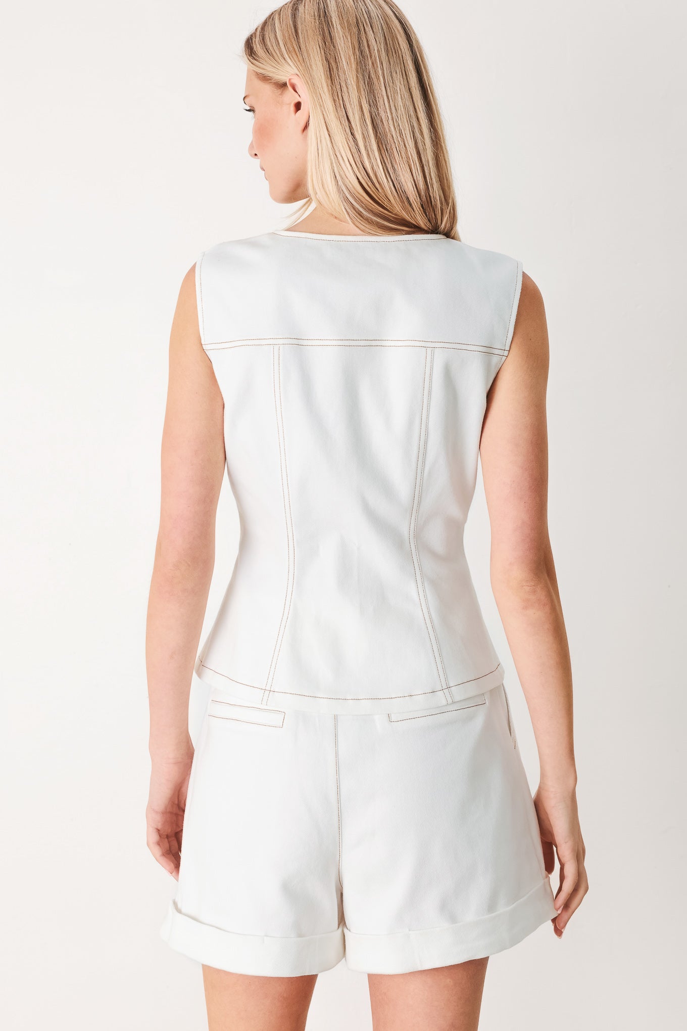 Woman wearing a white denim vest with round neckline, sleeveless and front closure with pockets | FREEMARKET
