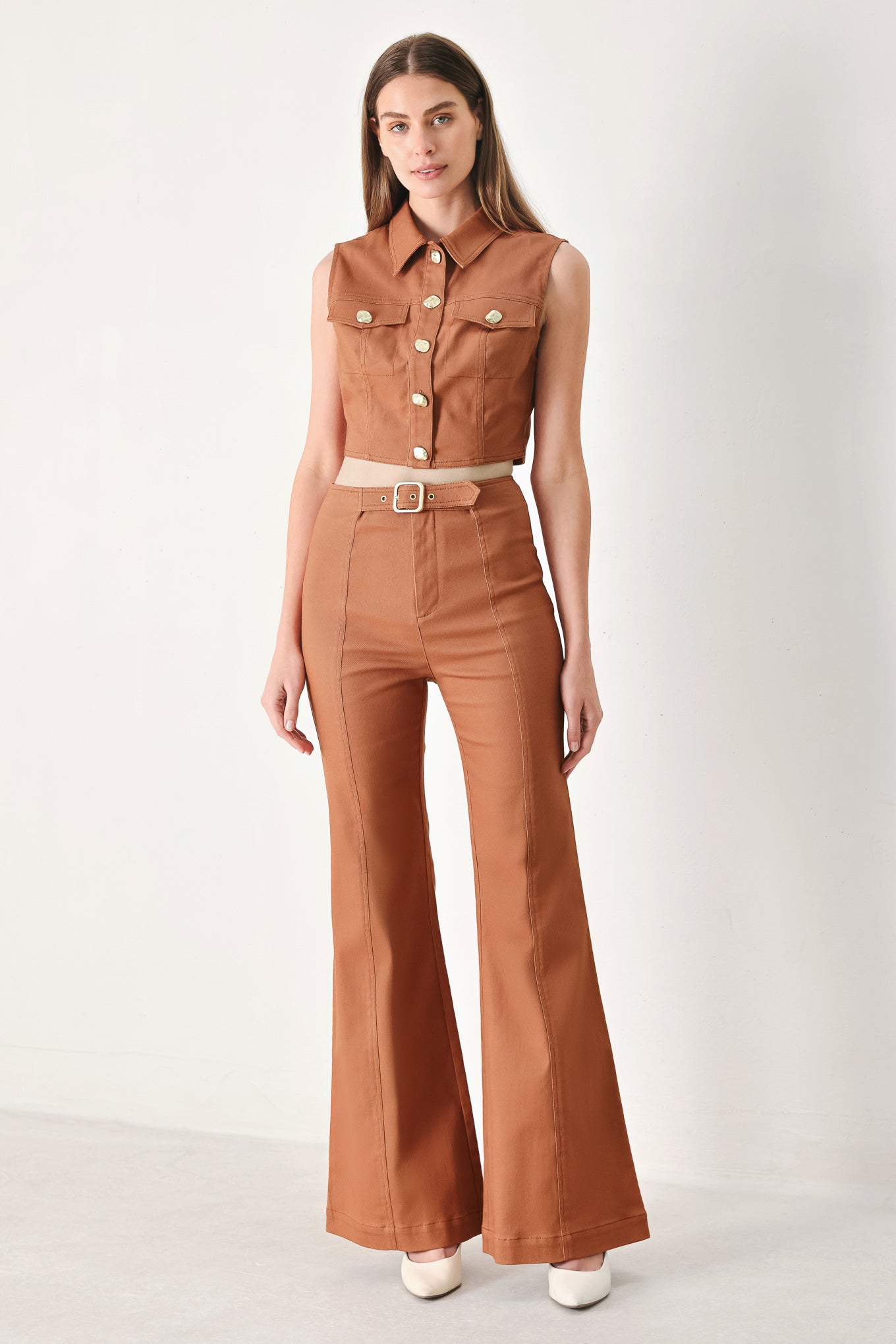Woman wearing a brown sleeveless crop top with collar, sleeveless, pockets and front button down | FREEMARKET | Flying Tomato