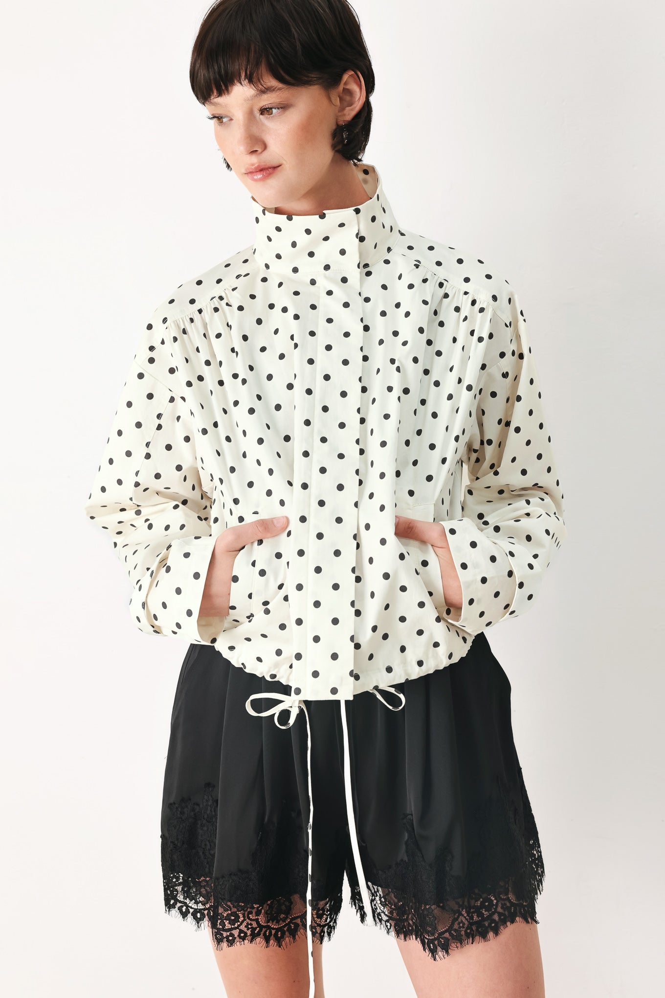 Woman wearing a polka dot jacket featuring funnel neck, long sleeve and front closure with waist tie | FREEMARKET