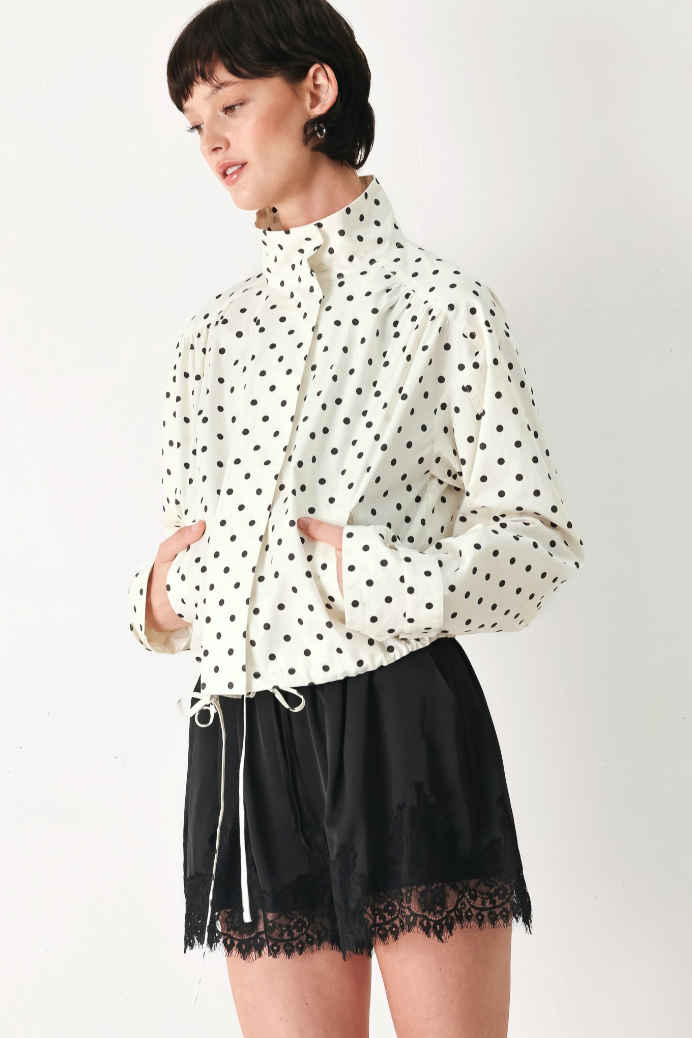Woman wearing a polka dot jacket featuring funnel neck, long sleeve and front closure with waist tie | FREEMARKET