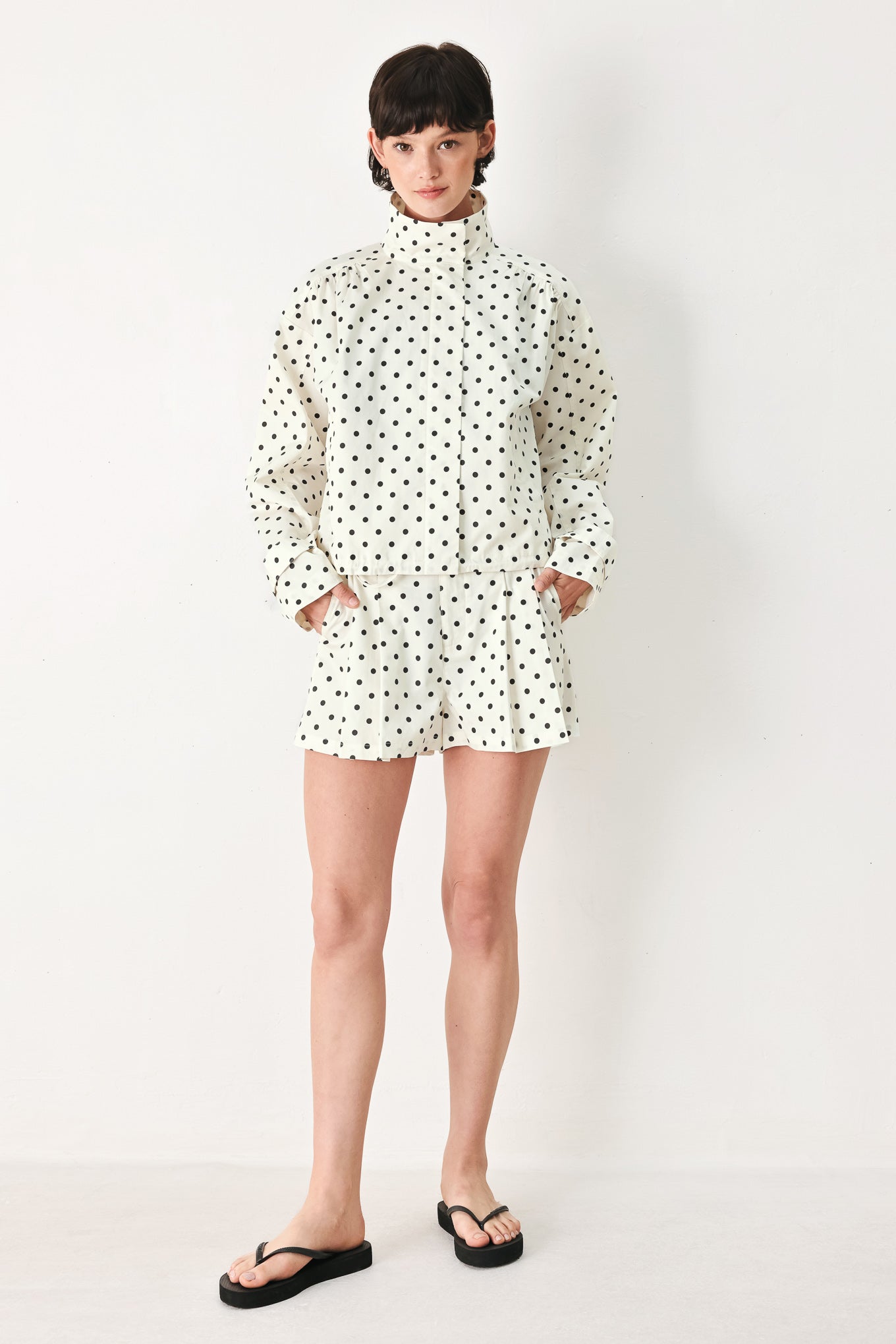 Woman wearing a polka dot jacket featuring funnel neck, long sleeve and front closure with waist tie | FREEMARKET