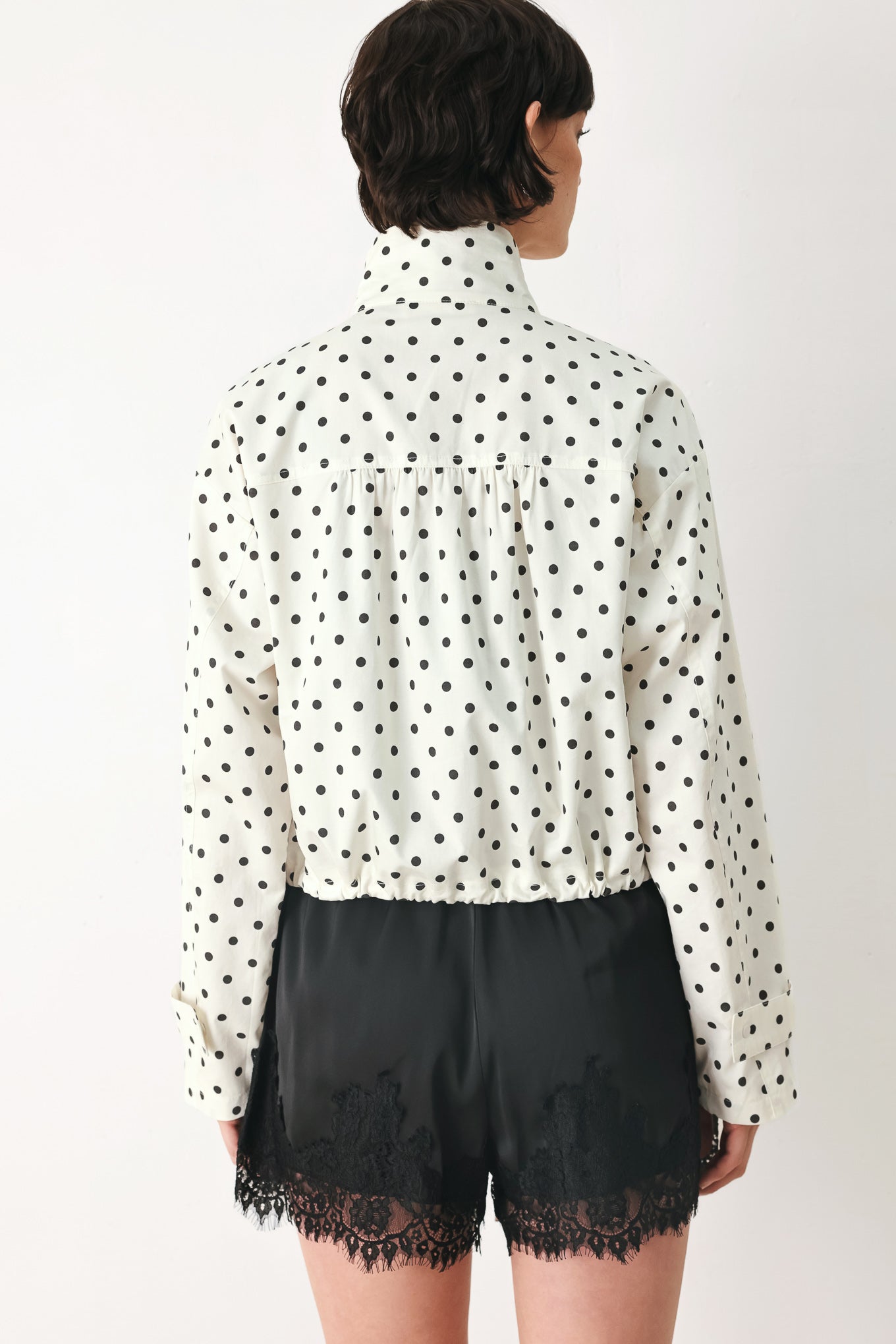 Woman wearing a polka dot jacket featuring funnel neck, long sleeve and front closure with waist tie | FREEMARKET