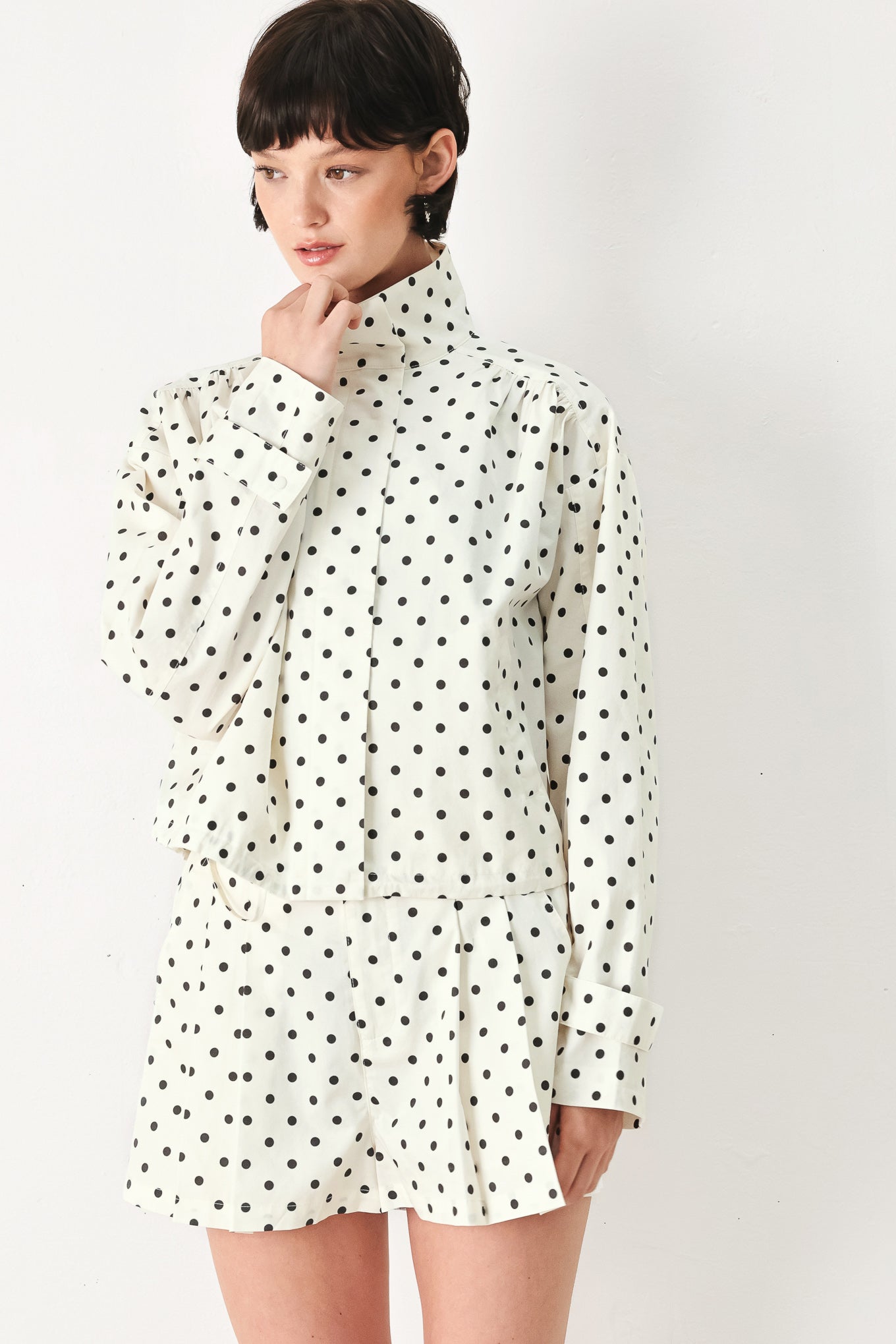 Woman wearing a polka dot jacket featuring funnel neck, long sleeve and front closure with waist tie | FREEMARKET
