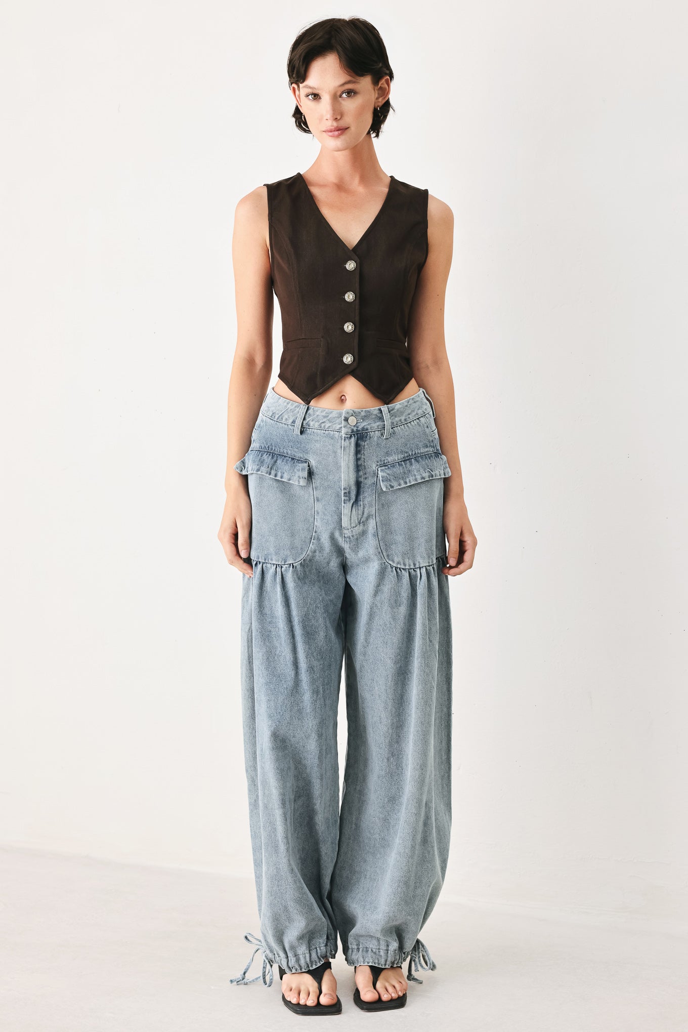 Woman wearing a brown sleeveless vest with buttons | FREEMARKET