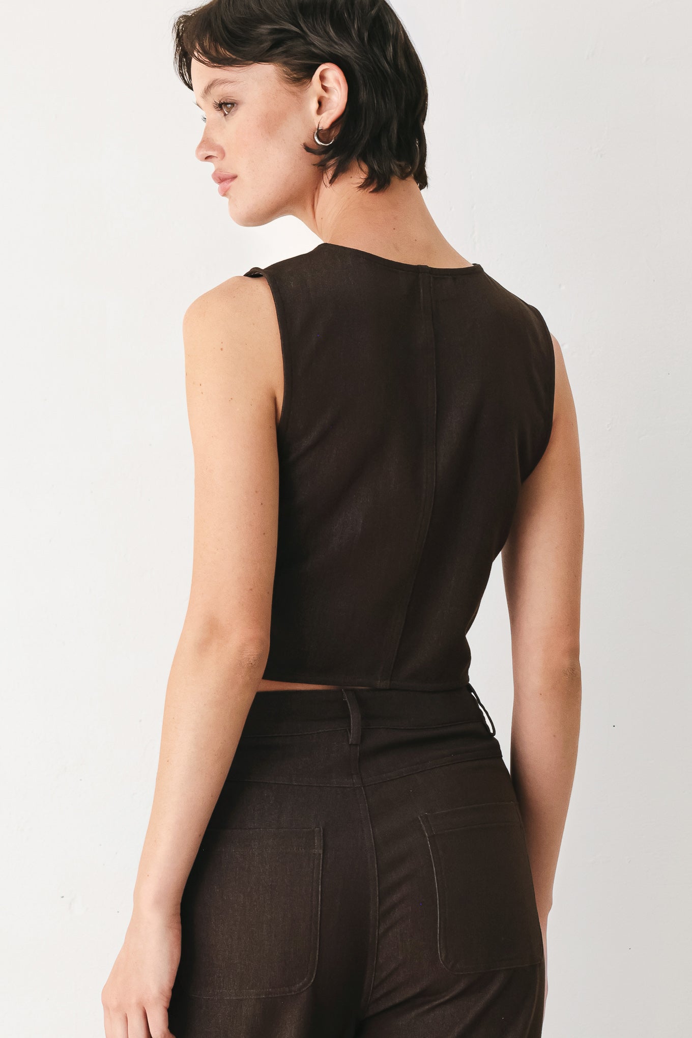 Woman wearing a brown sleeveless vest with buttons | FREEMARKET