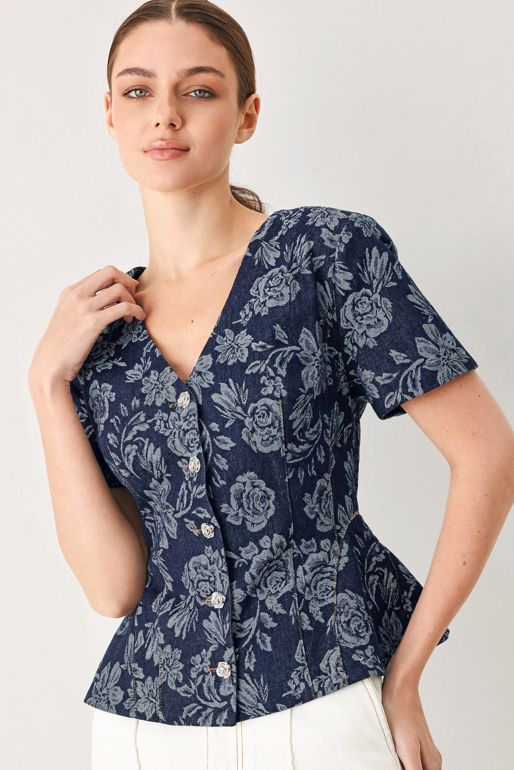 Woman wearing a denim woven jacquard top with V neckline, short sleeve, front button down and peplum | FREEMARKET