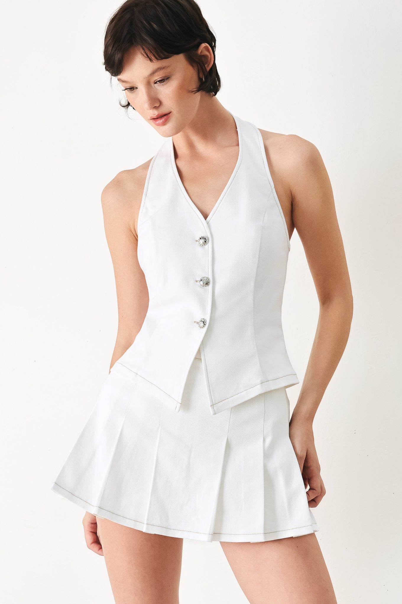 Woman wearing a white sleeveless halter vest and skort set | FREEMARKET