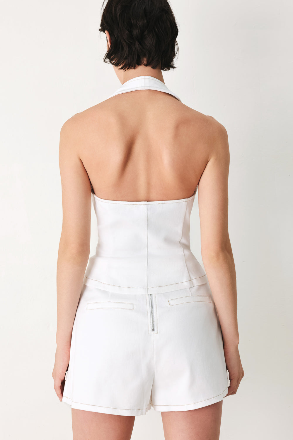 Woman wearing a white sleeveless halter vest and skort set | FREEMARKET