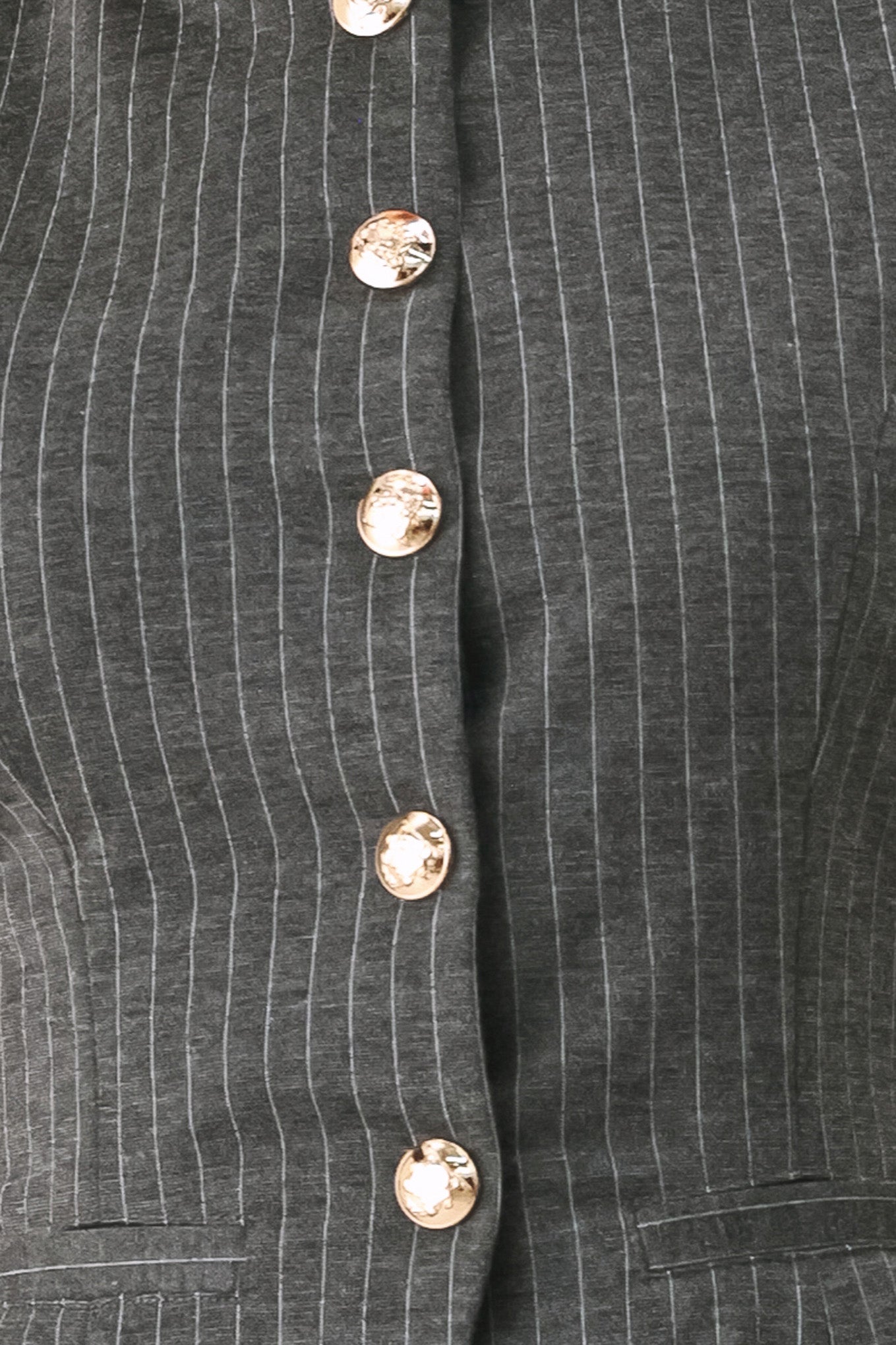 Woman wearing a charcoal and white striped stretch woven vest with wide neckline, sleeveless and front button closure | FREEMARKET