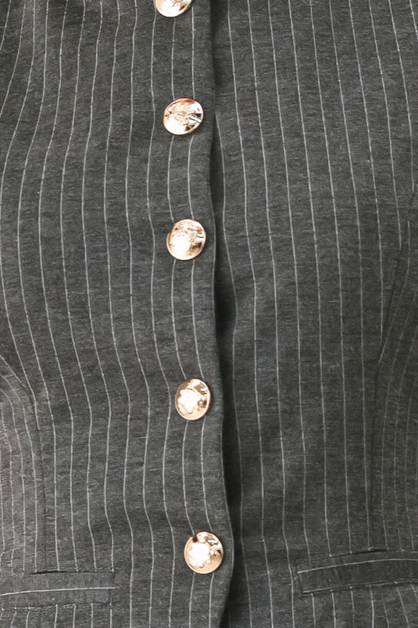 Woman wearing a charcoal and white striped stretch woven vest with wide neckline, sleeveless and front button closure | FREEMARKET