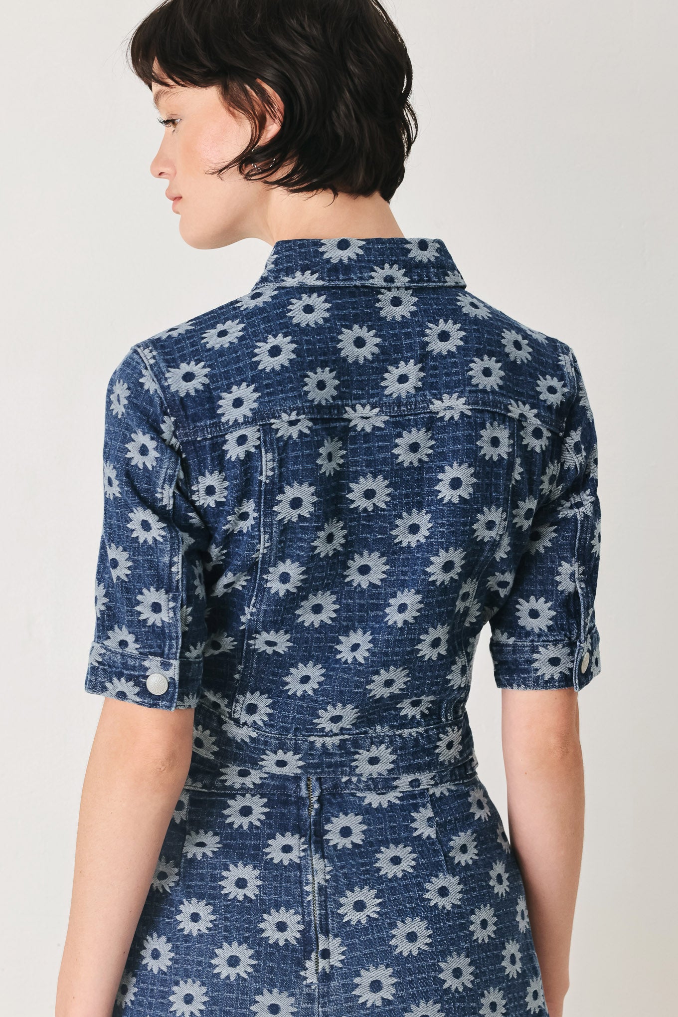 Woman wearing a blue denim floral patterned jacquard crop jacket featuring collar, elbow sleeve and front button closure | FREEMARKET
