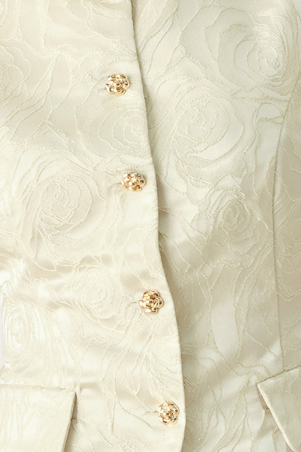 Woman wearing a sleeveless, button-front vest in a light cream or off-white jacquard fabric with small gold-tone buttons | FREEMARKET