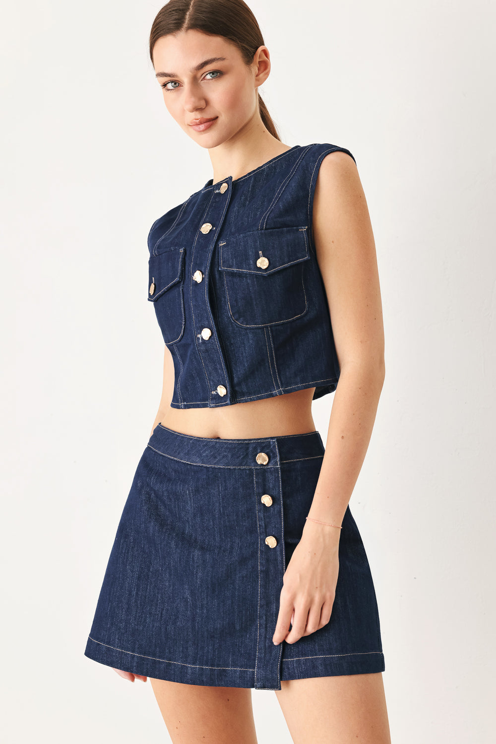 Woman wearing a denim denim crop vest with front button closure | FREEMARKET