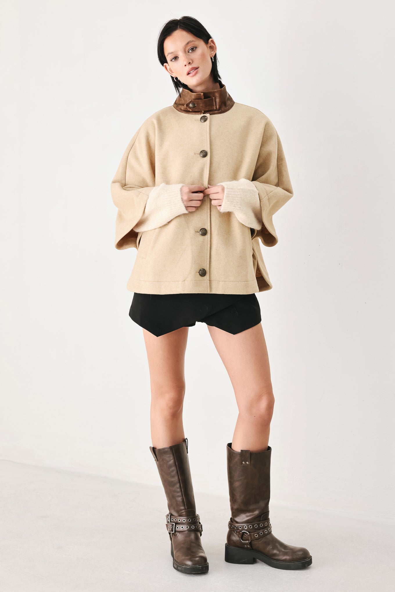 A model wearing a beige cropped cape jacket with a brown collar, buttoned front, and wide sleeves | FREEMARKET