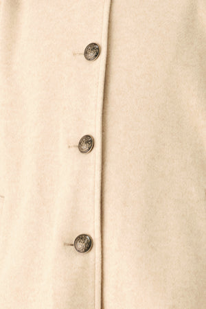 A model wearing a beige cropped cape jacket with a brown collar, buttoned front, and wide sleeves | FREEMARKET