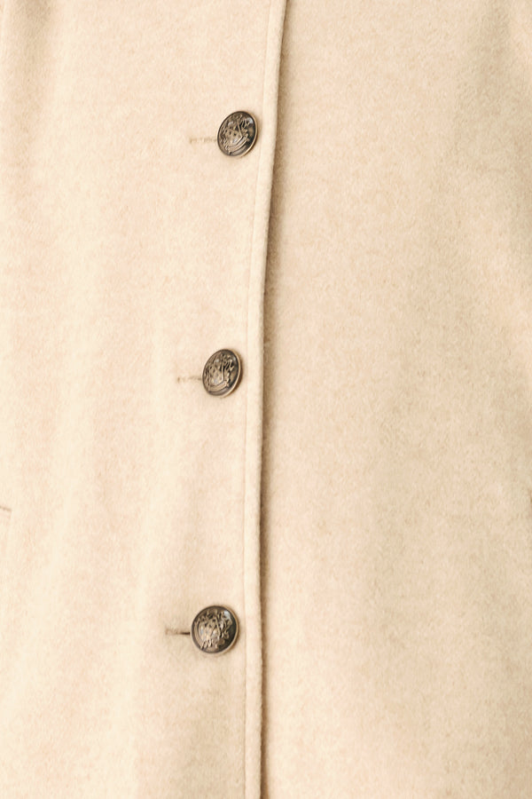 A model wearing a beige cropped cape jacket with a brown collar, buttoned front, and wide sleeves | FREEMARKET