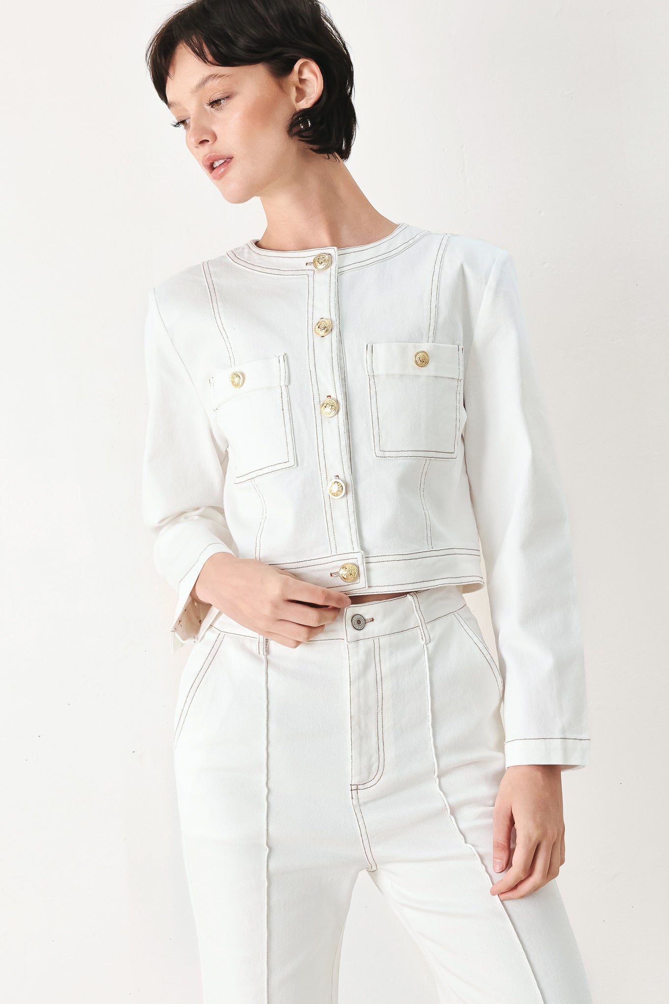 Woman wearing a white denim crop jacket featuring round neckline, long sleeve, pockets and front button down | FREEMARKET