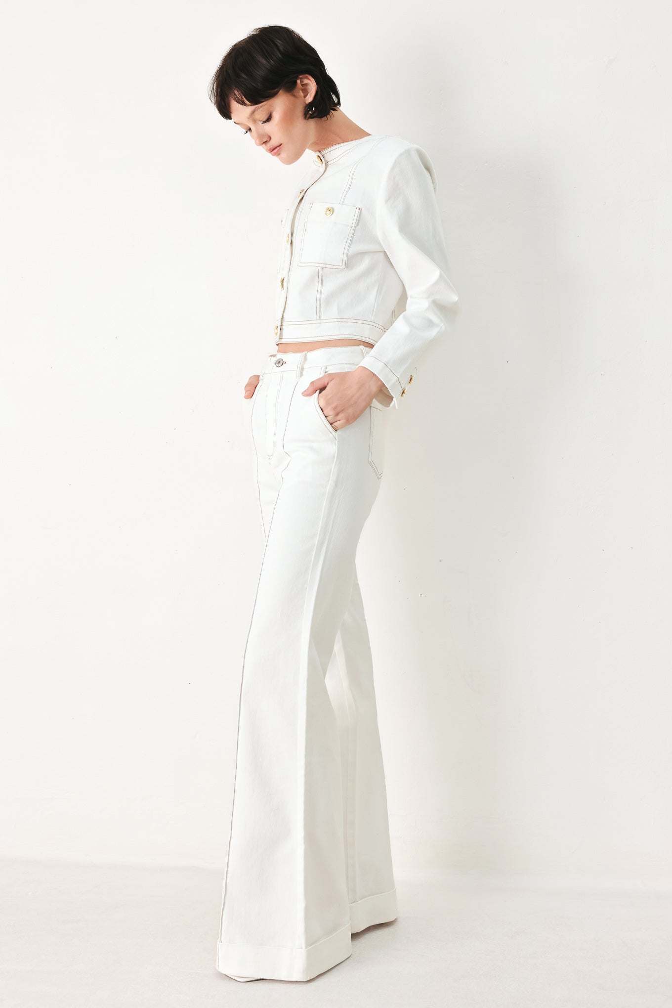 Woman wearing a white denim crop jacket featuring round neckline, long sleeve, pockets and front button down | FREEMARKET