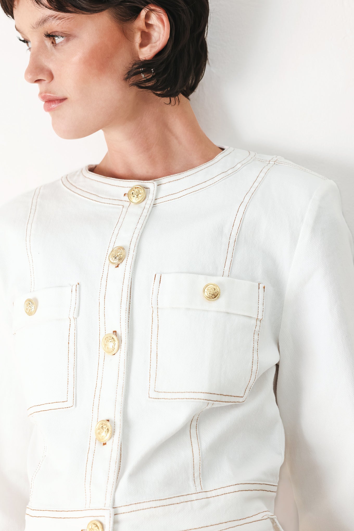 Woman wearing a white denim crop jacket featuring round neckline, long sleeve, pockets and front button down | FREEMARKET