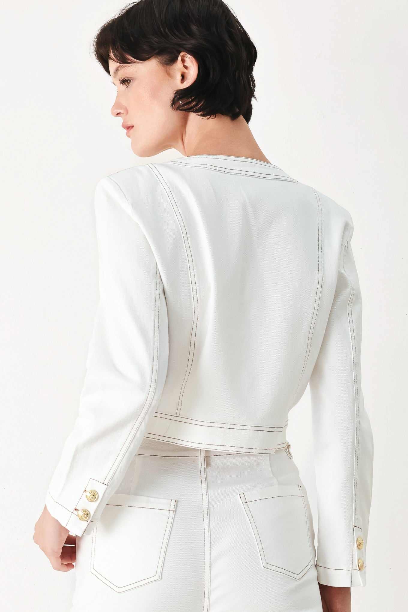 Woman wearing a white denim crop jacket featuring round neckline, long sleeve, pockets and front button down | FREEMARKET