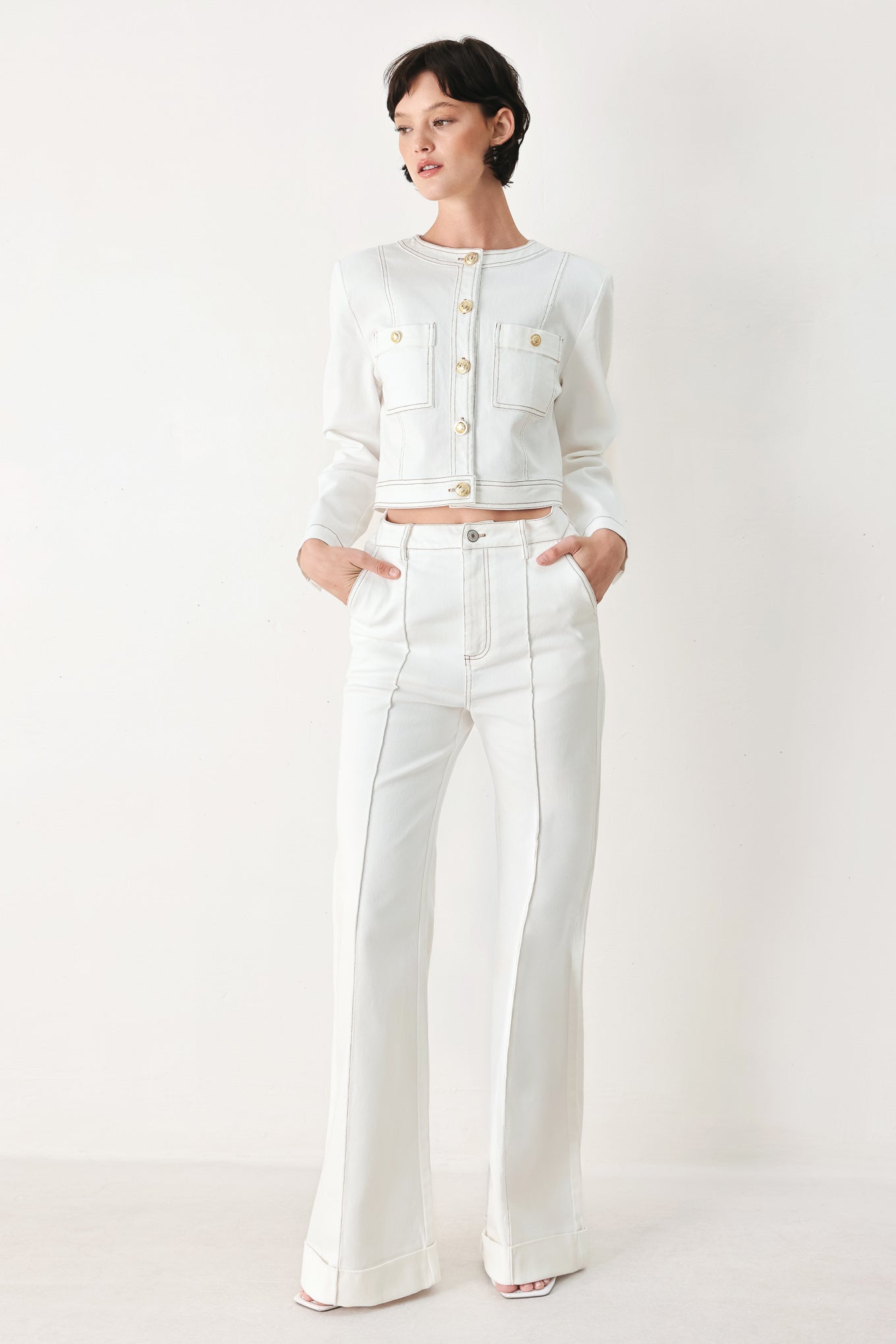 Woman wearing a white denim crop jacket featuring round neckline, long sleeve, pockets and front button down | FREEMARKET