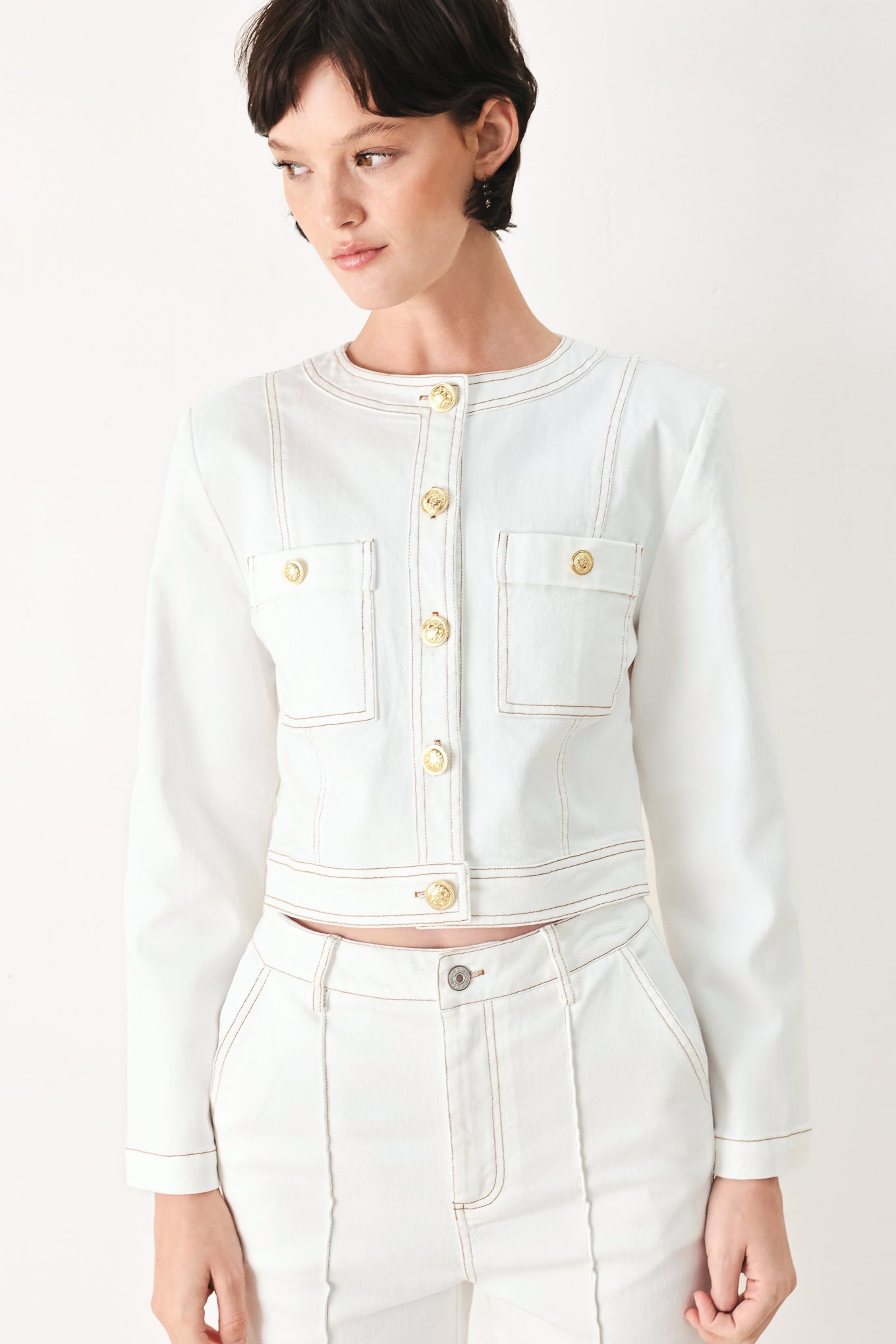 Woman wearing a white denim crop jacket featuring round neckline, long sleeve, pockets and front button down | FREEMARKET