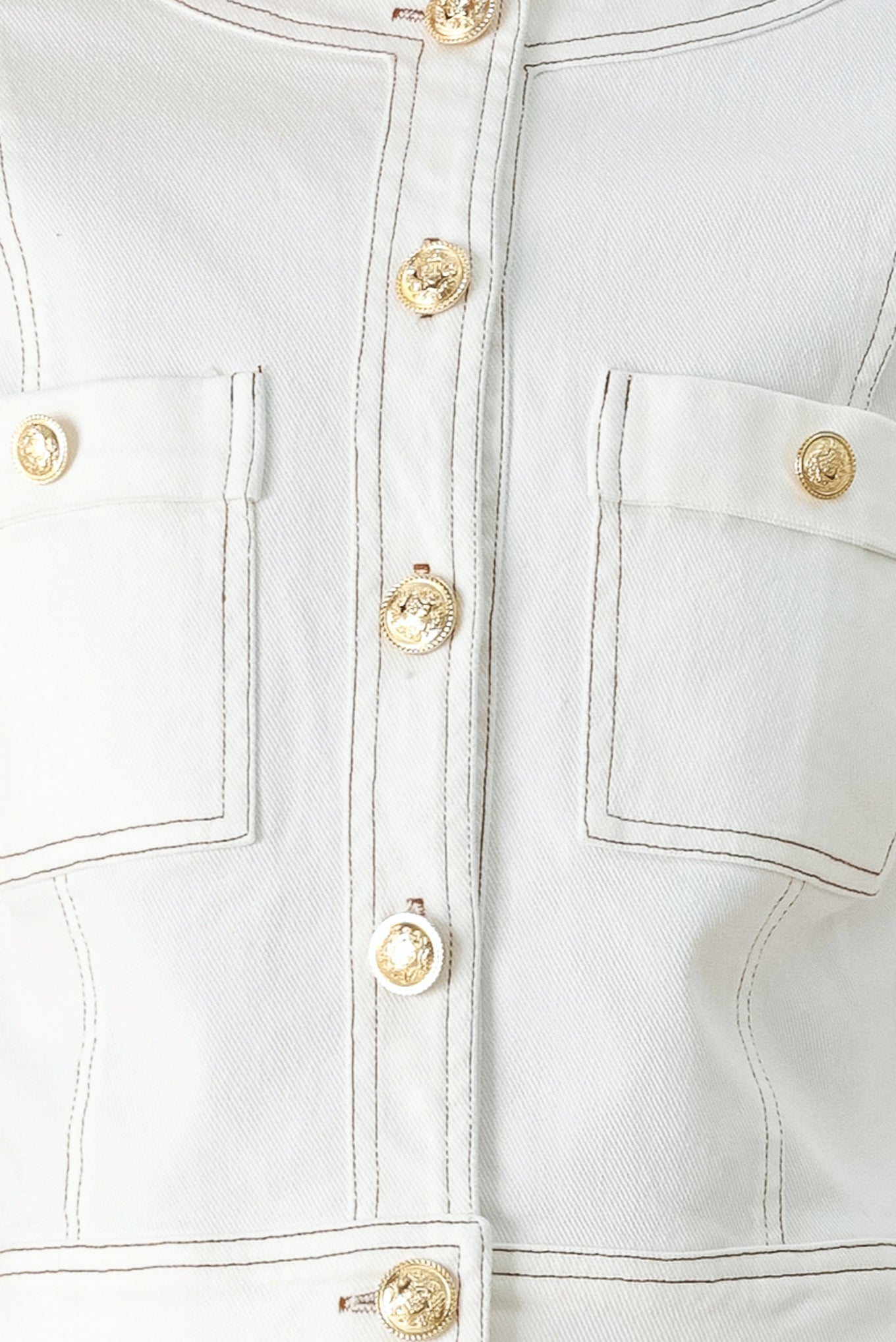 Close-up of a white denim jacket with gold buttons | FREEMARKET