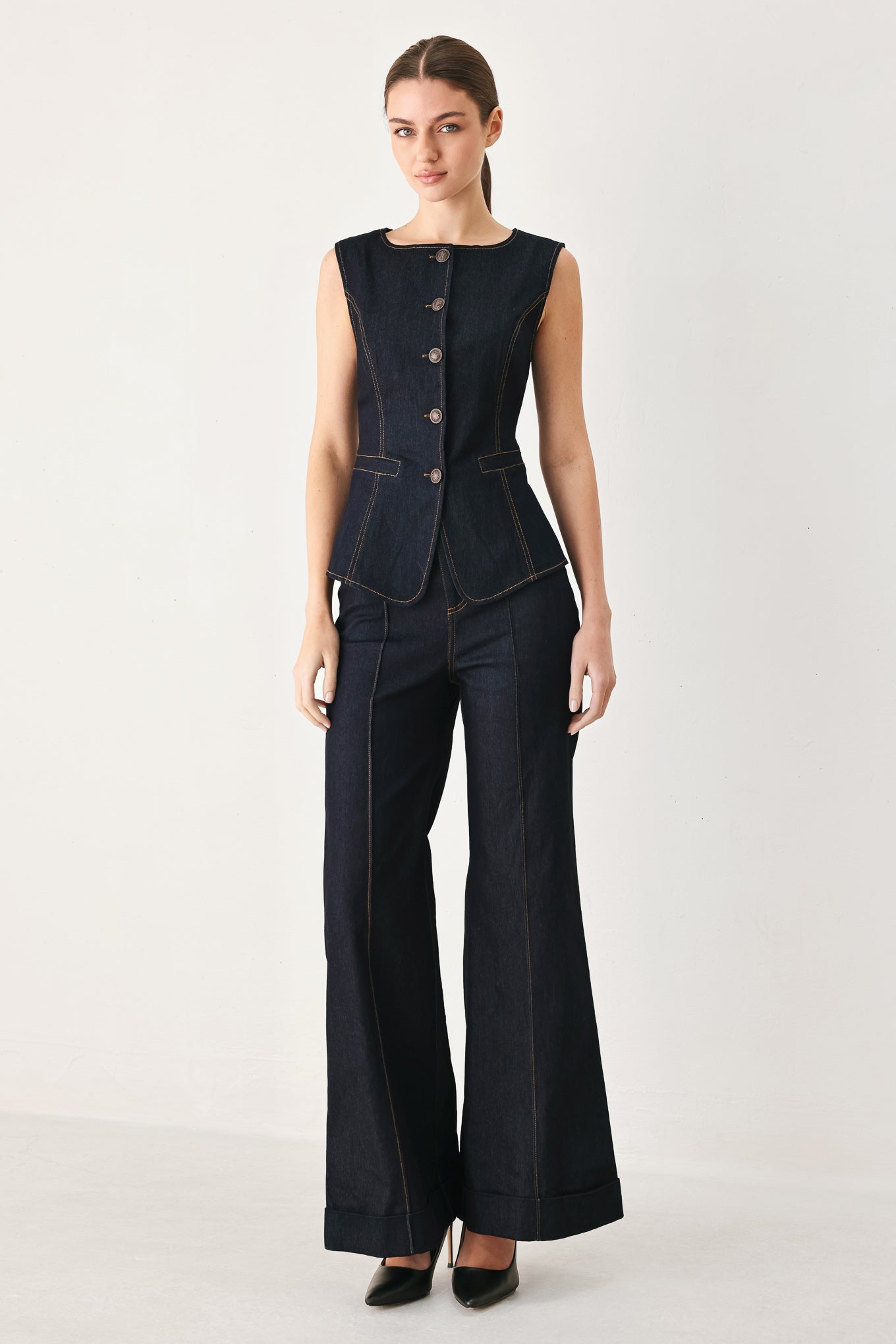 Woman wearing a dark denim vest with wide neckline and front button down | FREEMARKET