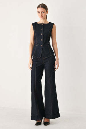 Woman wearing a dark denim vest with wide neckline and front button down | FREEMARKET