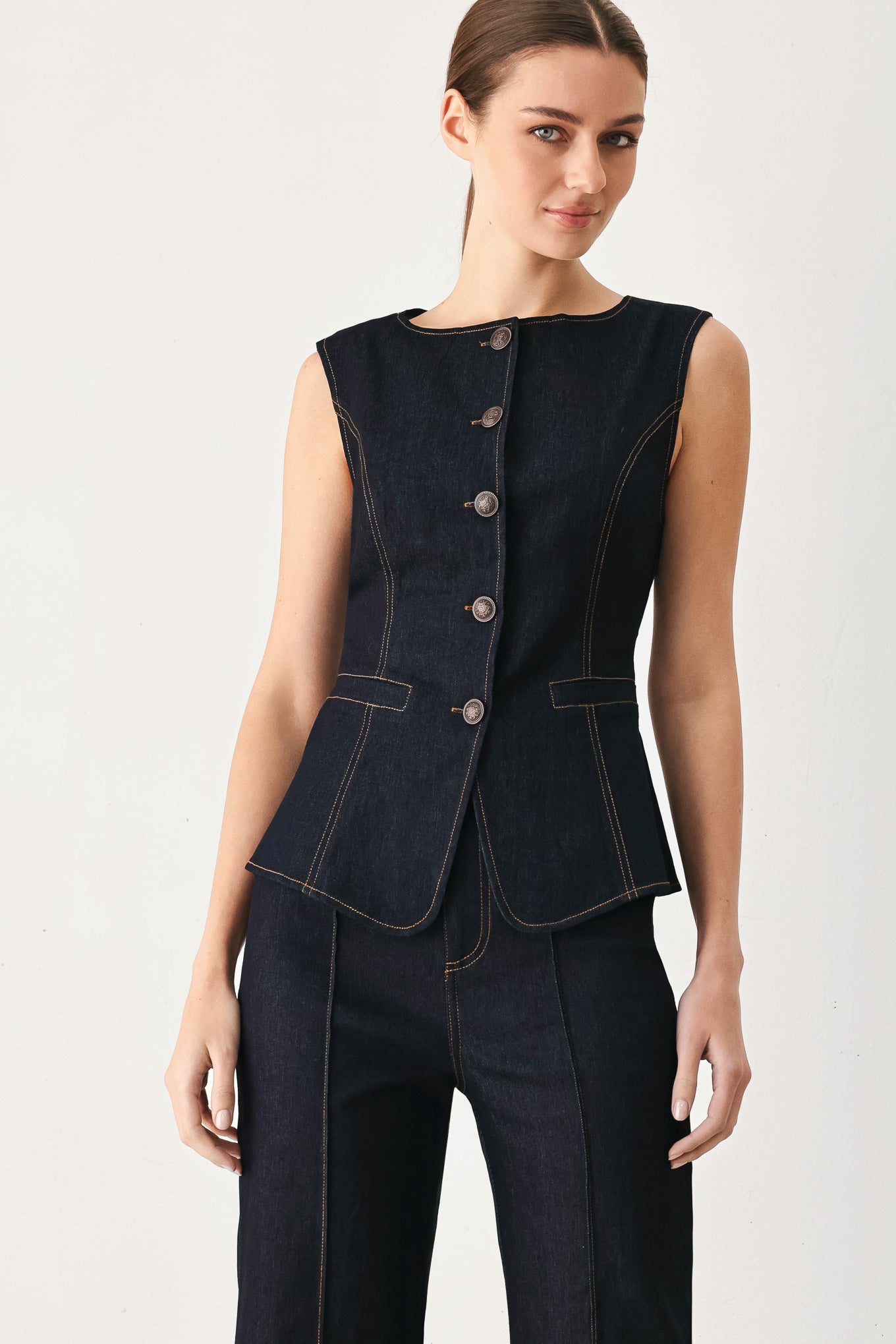 Woman wearing a dark denim vest with wide neckline and front button down | FREEMARKET