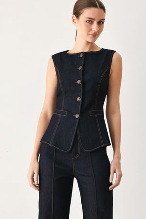 Woman wearing a dark denim vest with wide neckline and front button down | FREEMARKET