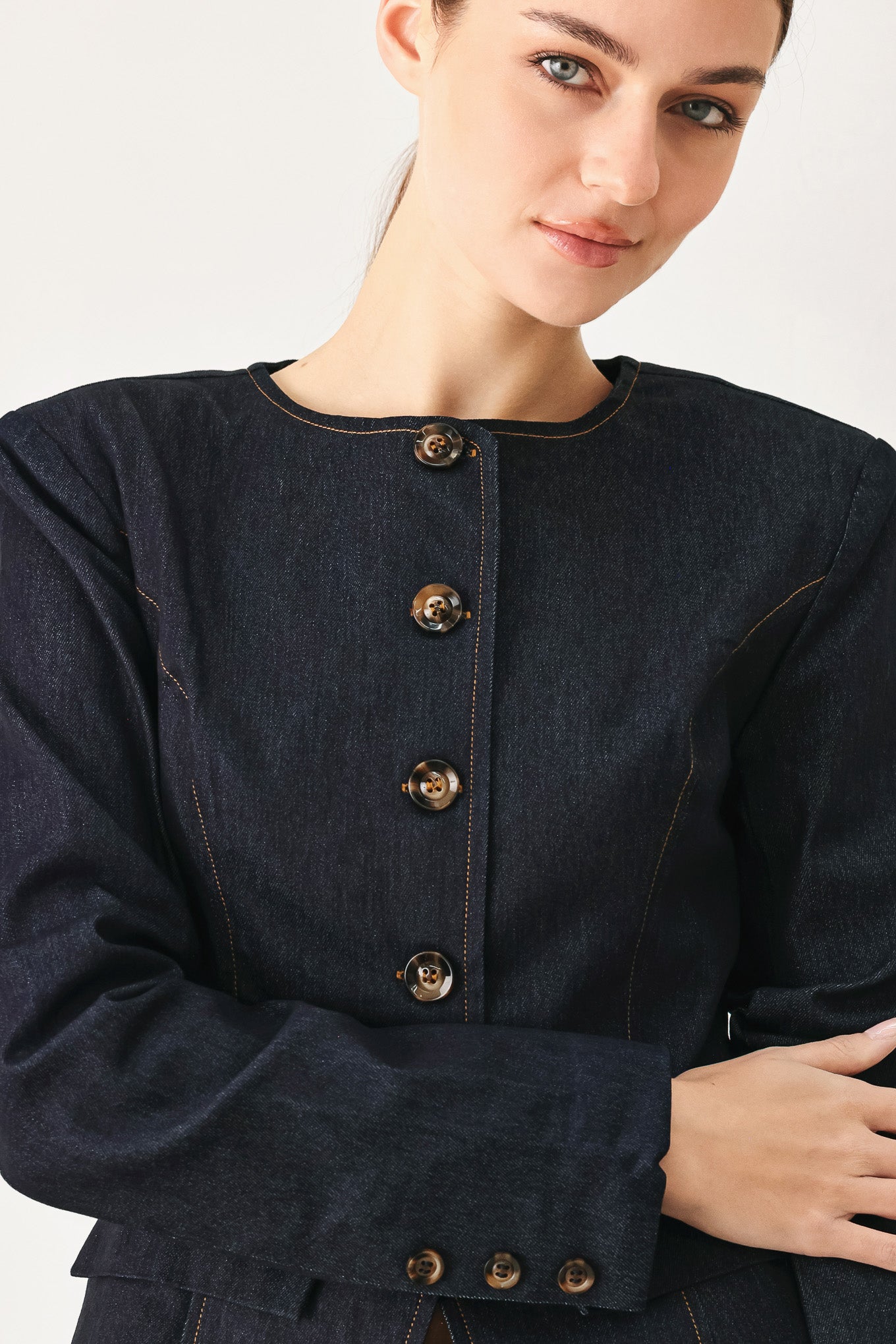 Woman wearing a dark denim jacket with round neckline, long sleeve and front button closure | FREEMARKET