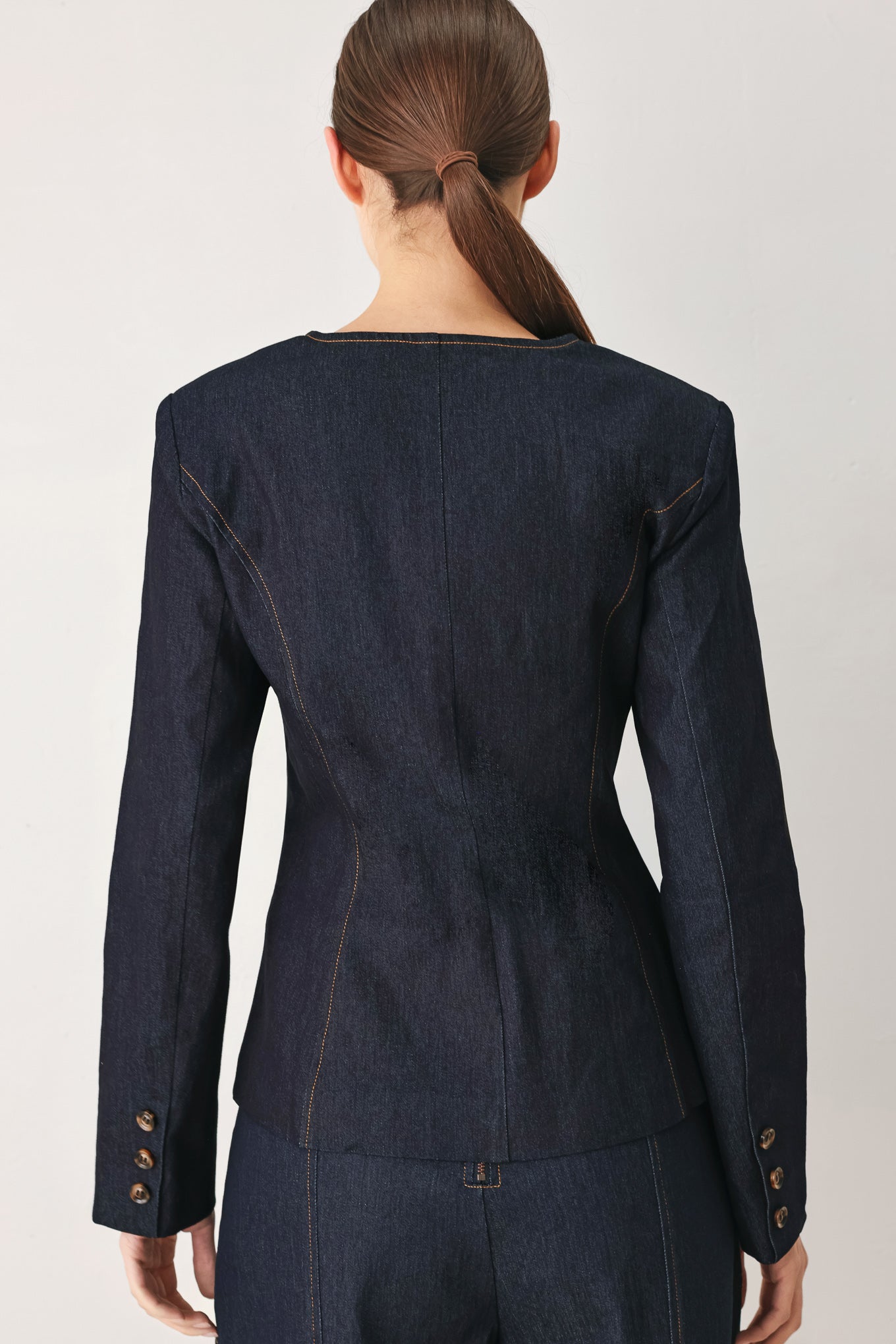 Woman wearing a dark denim jacket with round neckline, long sleeve and front button closure | FREEMARKET