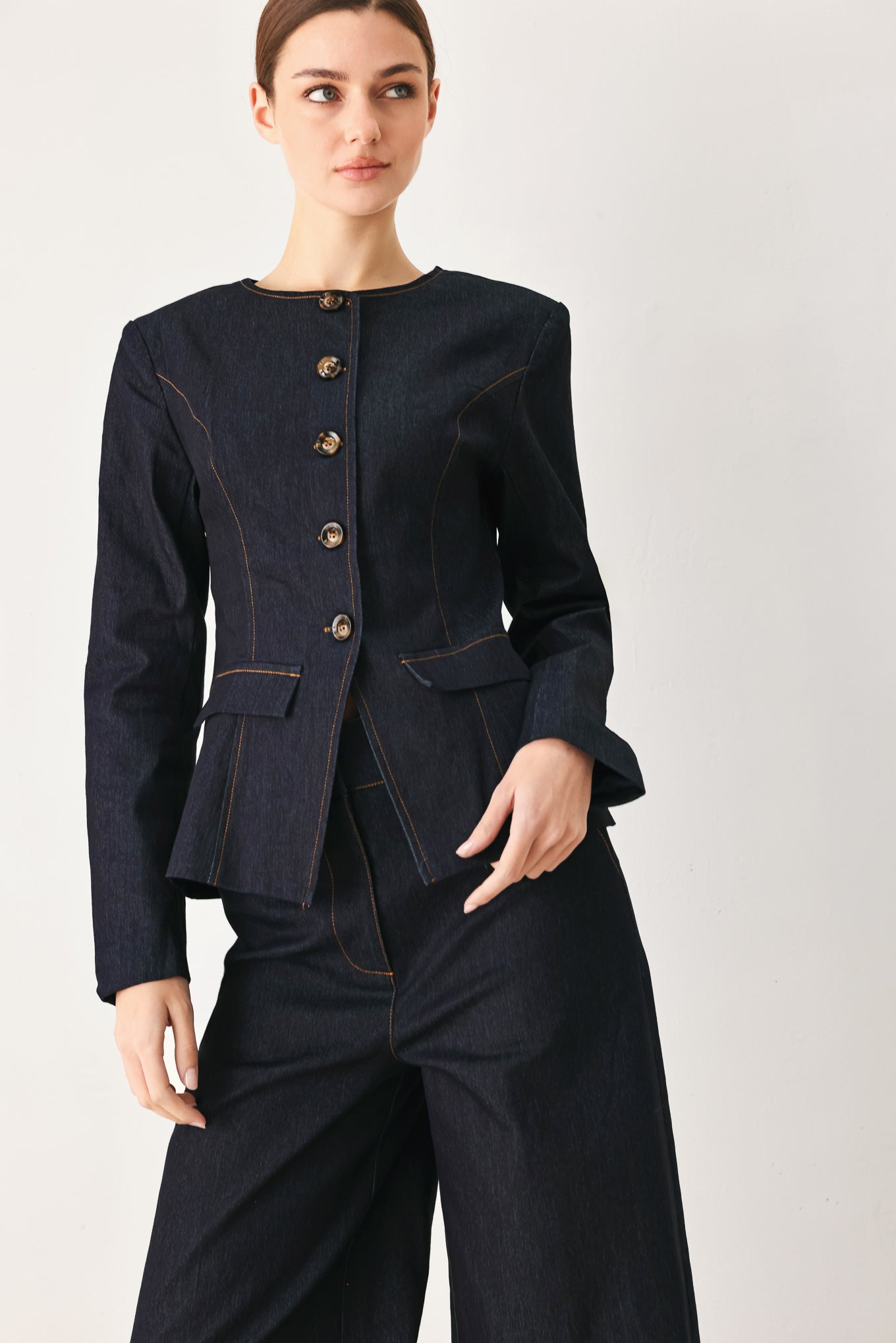 Woman wearing a dark denim jacket with round neckline, long sleeve and front button closure | FREEMARKET