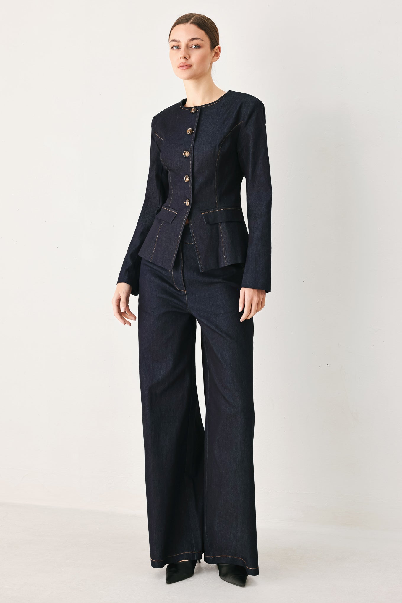 Woman wearing a dark denim jacket with round neckline, long sleeve and front button closure | FREEMARKET